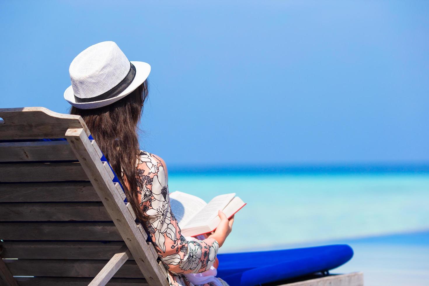 kvinna som läser en bok på stranden foto