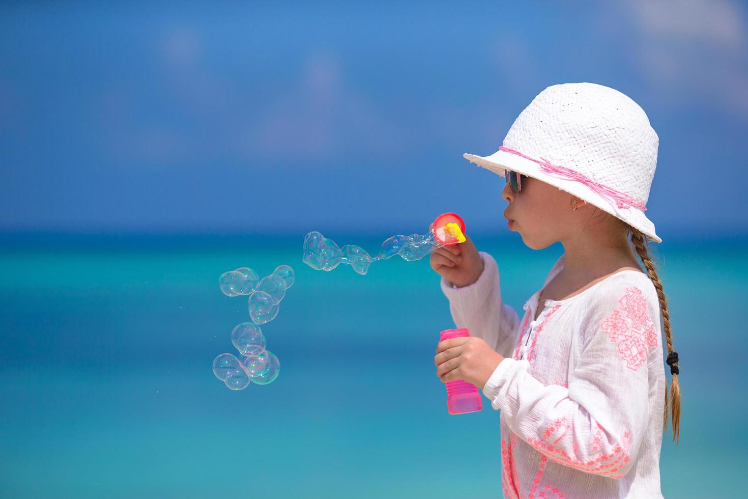flicka som blåser bubblor på stranden foto