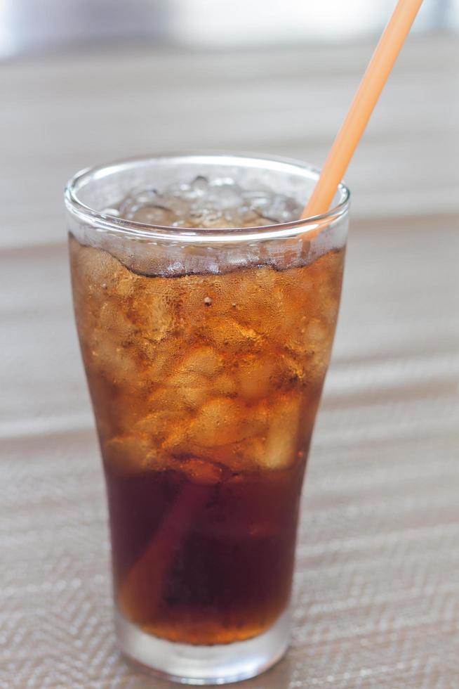 glas cola på ett bord foto
