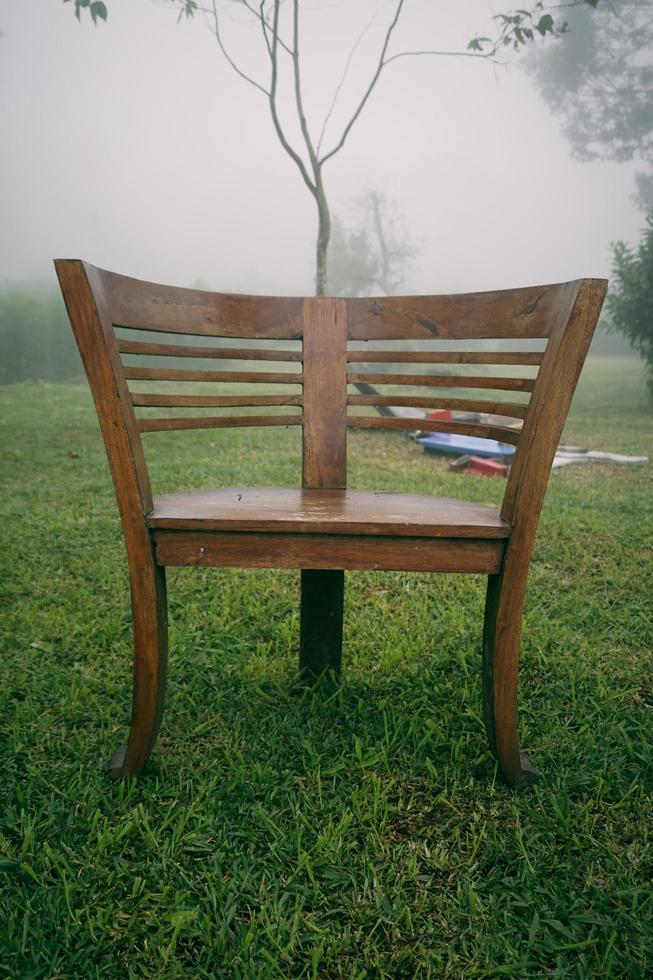 runda trä- stol i de trädgård med dimmig bakgrund i de morgon. trä- ärm stol foto