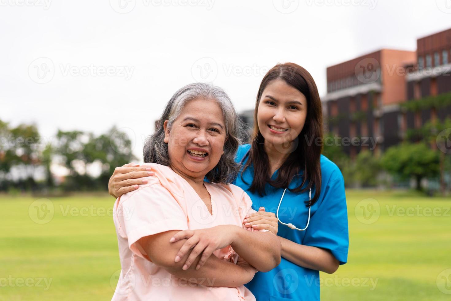 asiatisk försiktig vårdgivare eller sjuksköterska håll de patient hand och uppmuntra de patient i en trädgård. begrepp av Lycklig pensionering med vård från en vårdgivare och besparingar och senior hälsa försäkring. foto