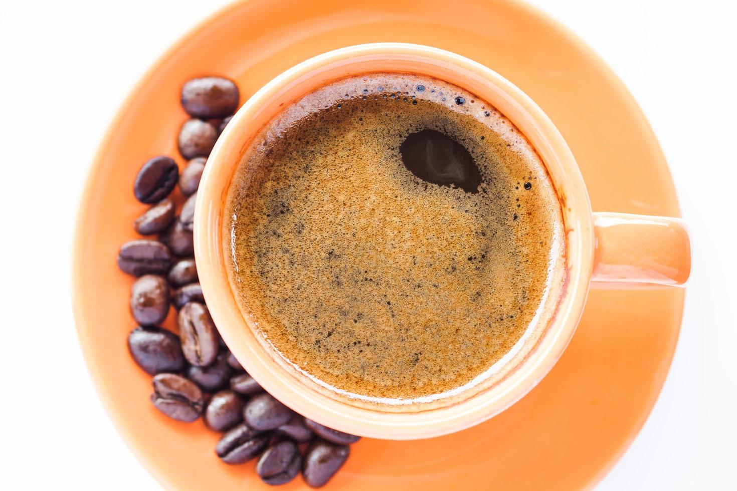 espressokopp och rostat kaffe på en vit bakgrund foto