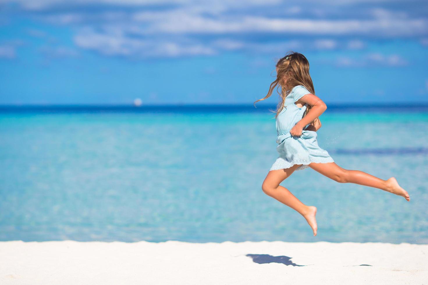 flicka som hoppar på en strand foto