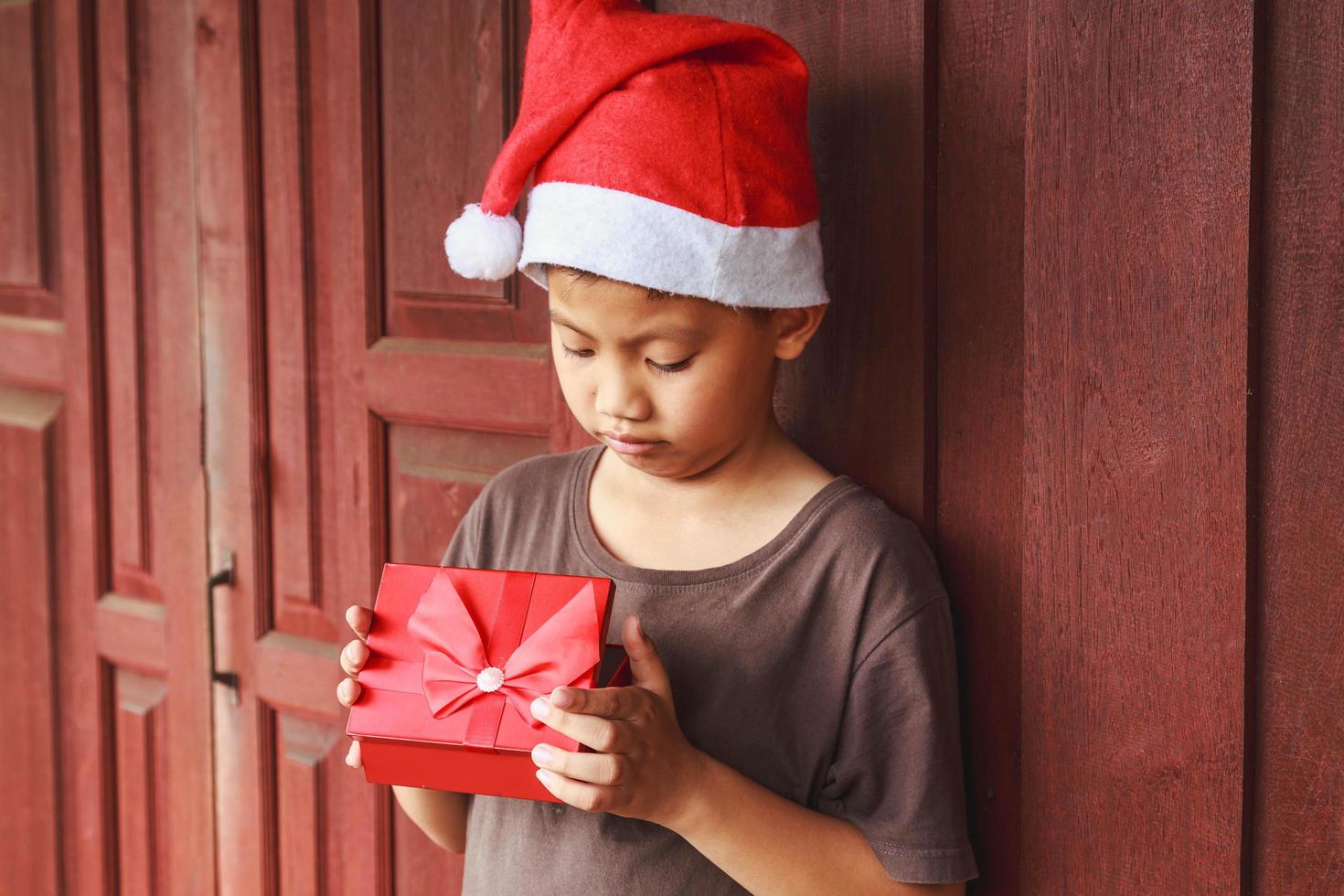 pojke med presentask på juldagen foto