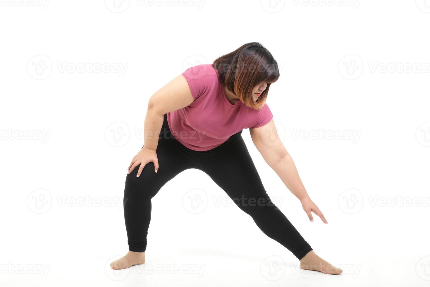fett asiatisk kvinna utövar do sträckor av vapen och ben. stanna kvar på en vit bakgrund. de begrepp av förlorande vikt, fett brinnande, övning för vistas friska. isolerat foto