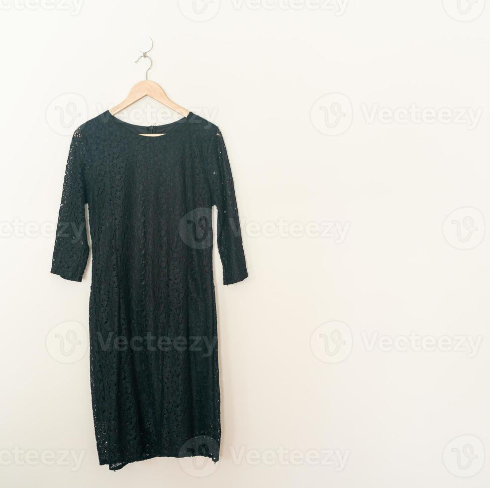 vacker svart klänning hängande på väggen foto