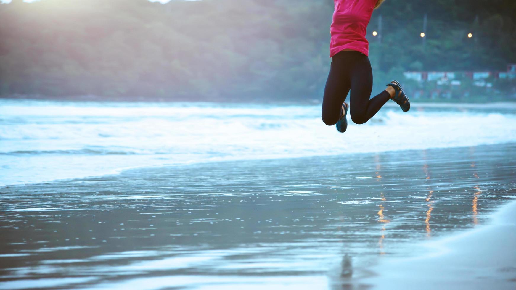 kvinna joggning träna på de strand i de morgon. koppla av med de hav promenad. hoppa upp och roligt på träna. foto