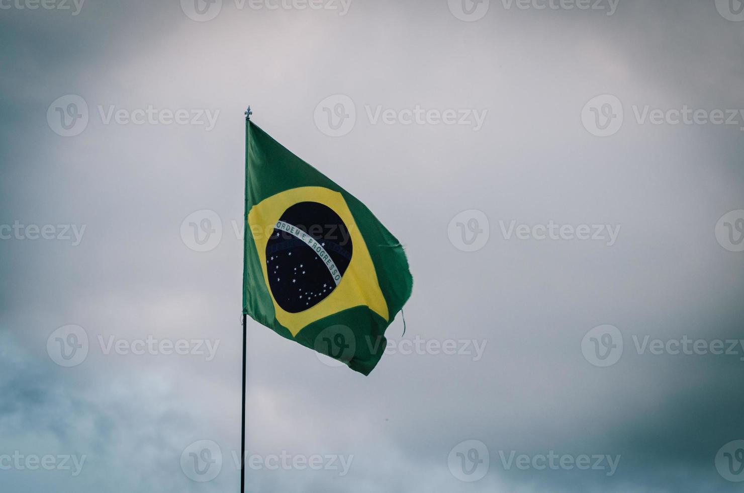 Brasilien flagga vinka i en Pol med molnig himmel foto