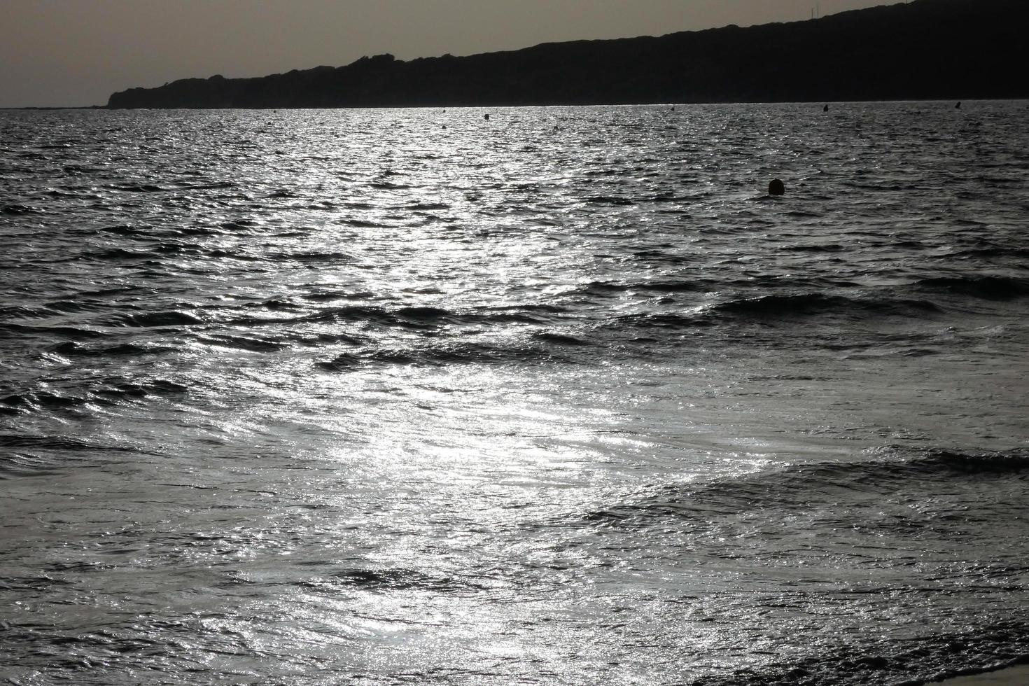 ensam, trångt strand med lugna hav och små vågor foto