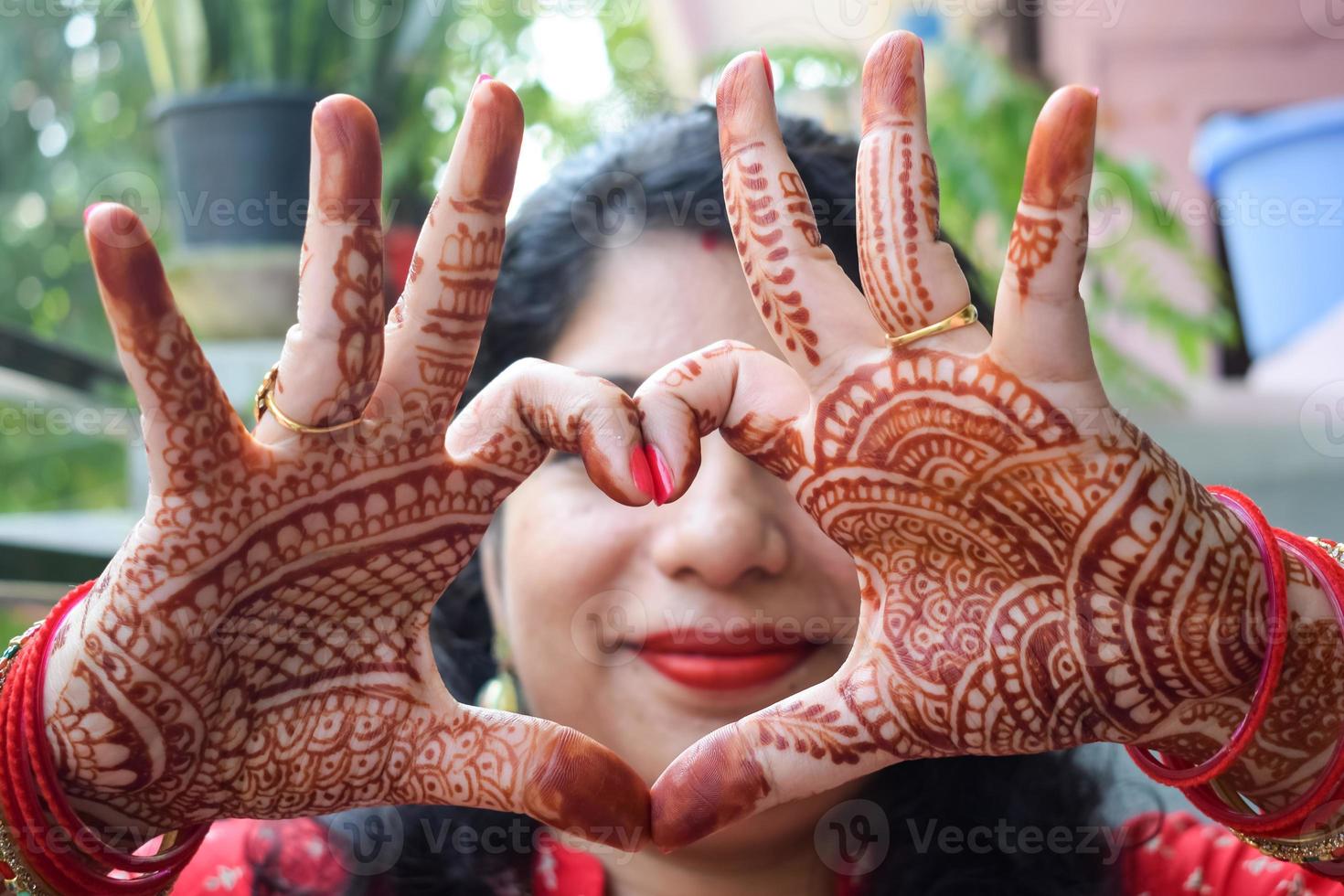 skön kvinna klädd upp som indisk tradition med henna mehndi design på henne både händer till fira stor festival av karwa chauth, karwa kauth fester förbi indisk kvinna för henne Make foto