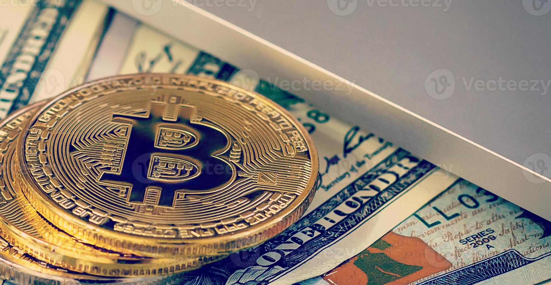 bitcoin gyllene mynt på en dollar sedlar kontor bakgrund vit bärbar dator mobil foto