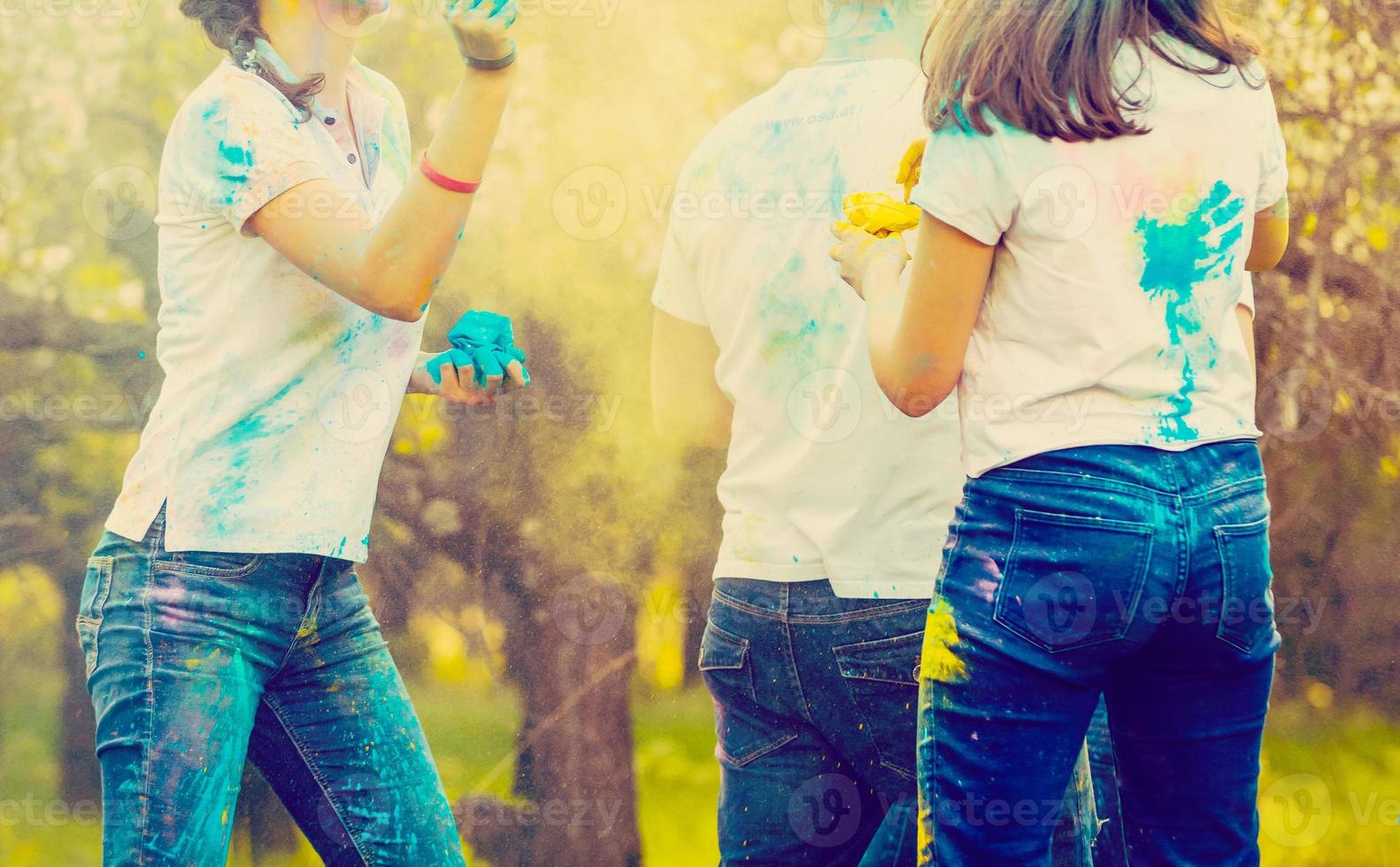 Lycklig vänner festa med färgrik pulver moln på holi festival i sommar tid - ung människor har roligt på de strand fest - ungdom och vänskap begrepp - fokus på Centrum flickor ansikte - värma filtrera foto