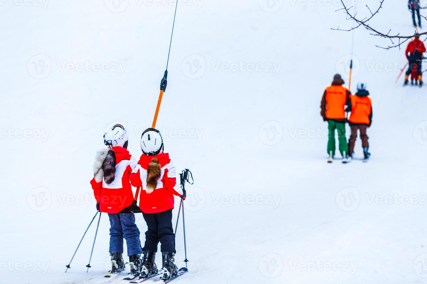 barn på en åka skidor hiss, skidlift och snötäckt berg. foto