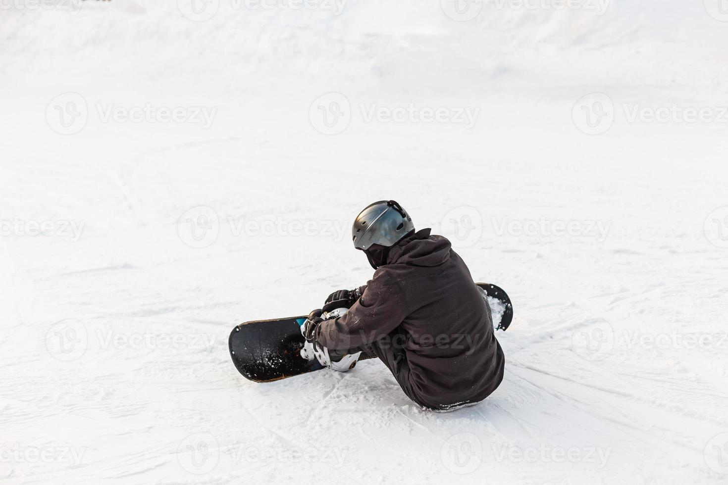 snowboardåkare Sammanträde. vinter- sport begrepp med äventyr kille på topp av berg redo till rida ner foto