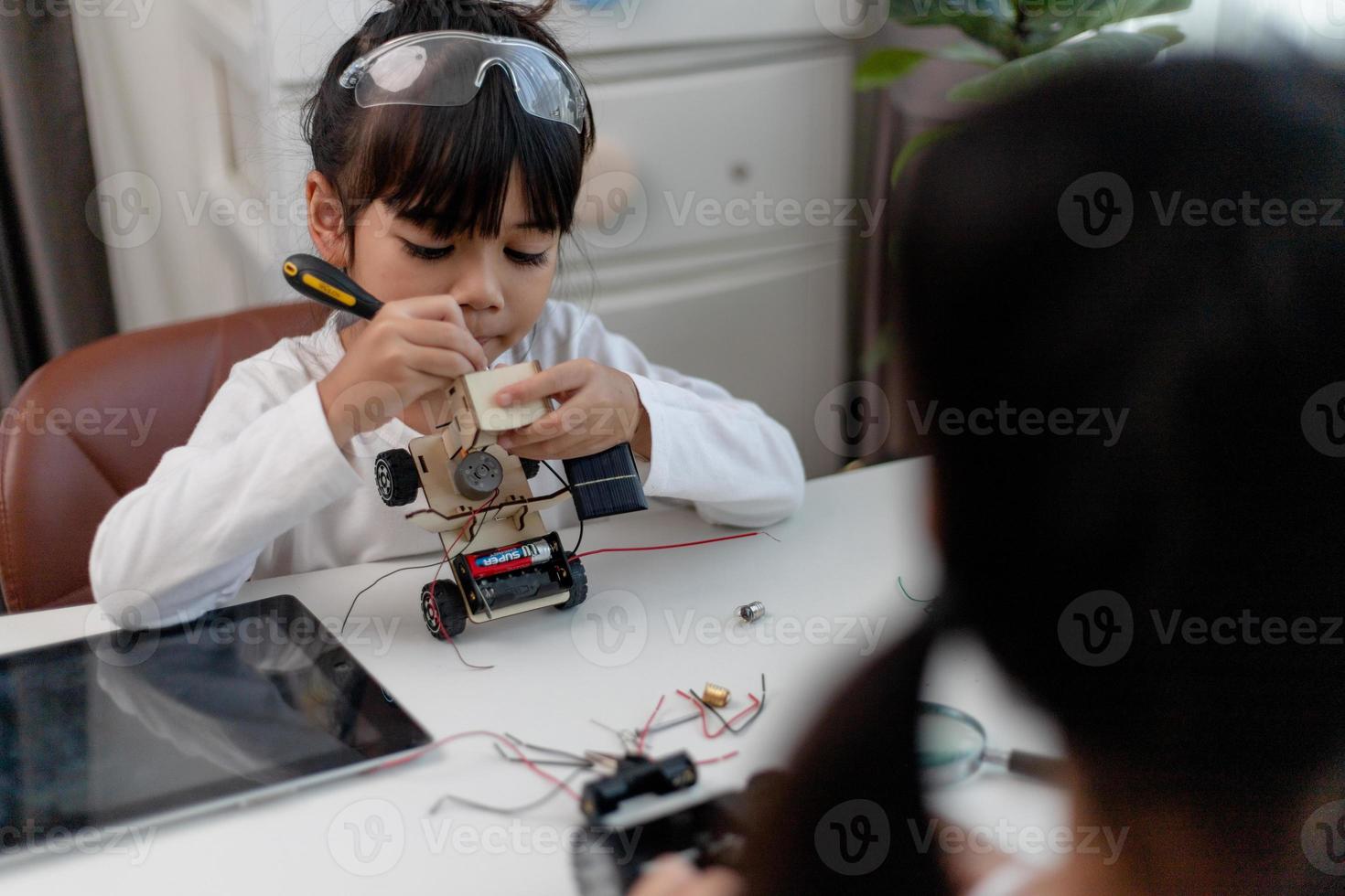Asien-studenter lär sig hemma i kodning av robotbilar och kablar för elektronikkort i stam, steam, matematik ingenjör vetenskapsteknik datorkod i robotik för barn-koncept. foto