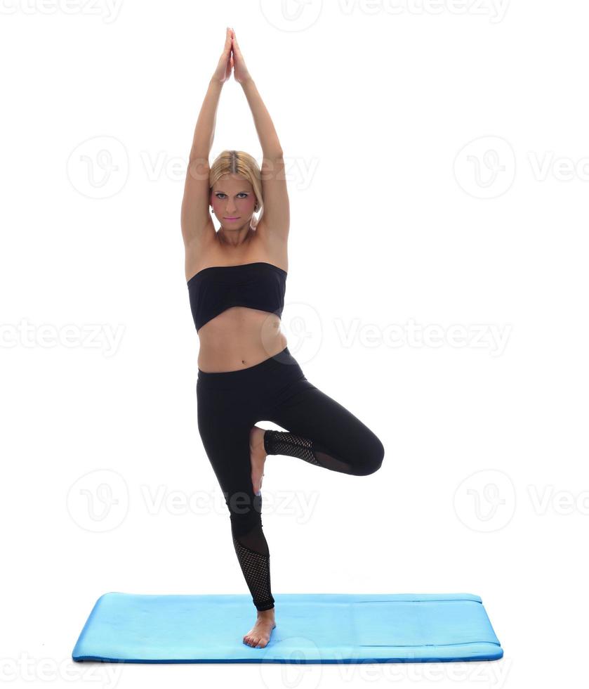 sportig ung kvinna håller på med yoga öva isolerat på vit bakgrund. foto