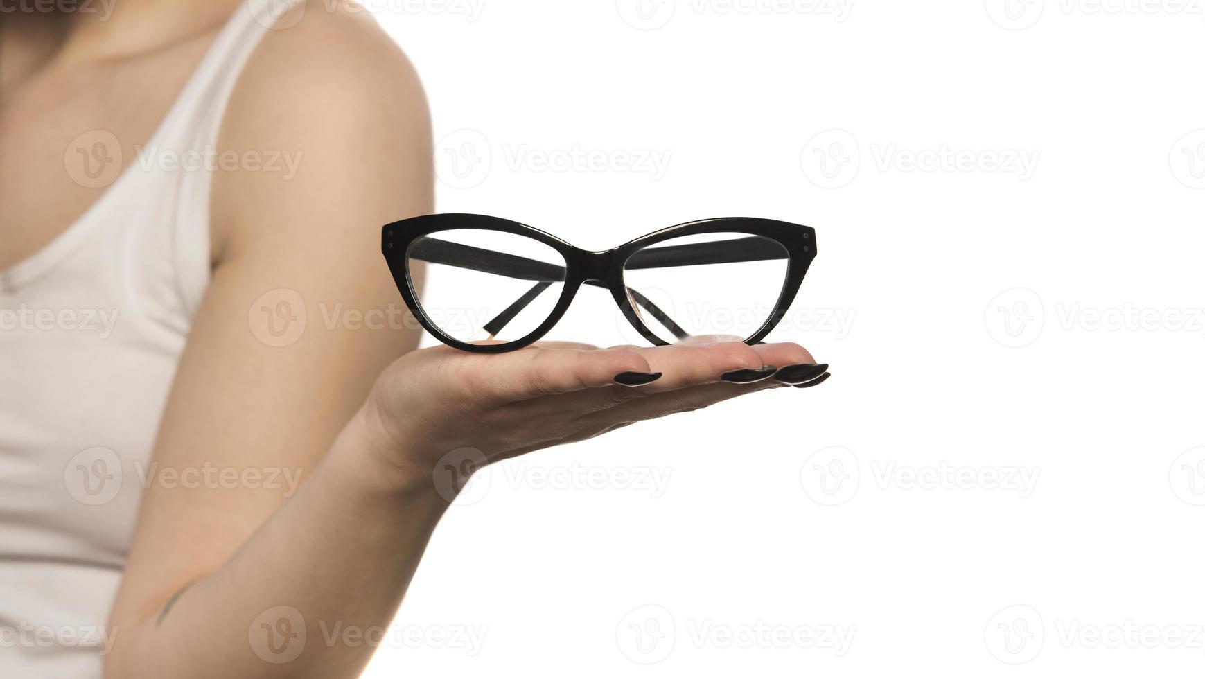 kvinna innehav glasögon på henne handflatan. isolerat på vit bakgrund foto