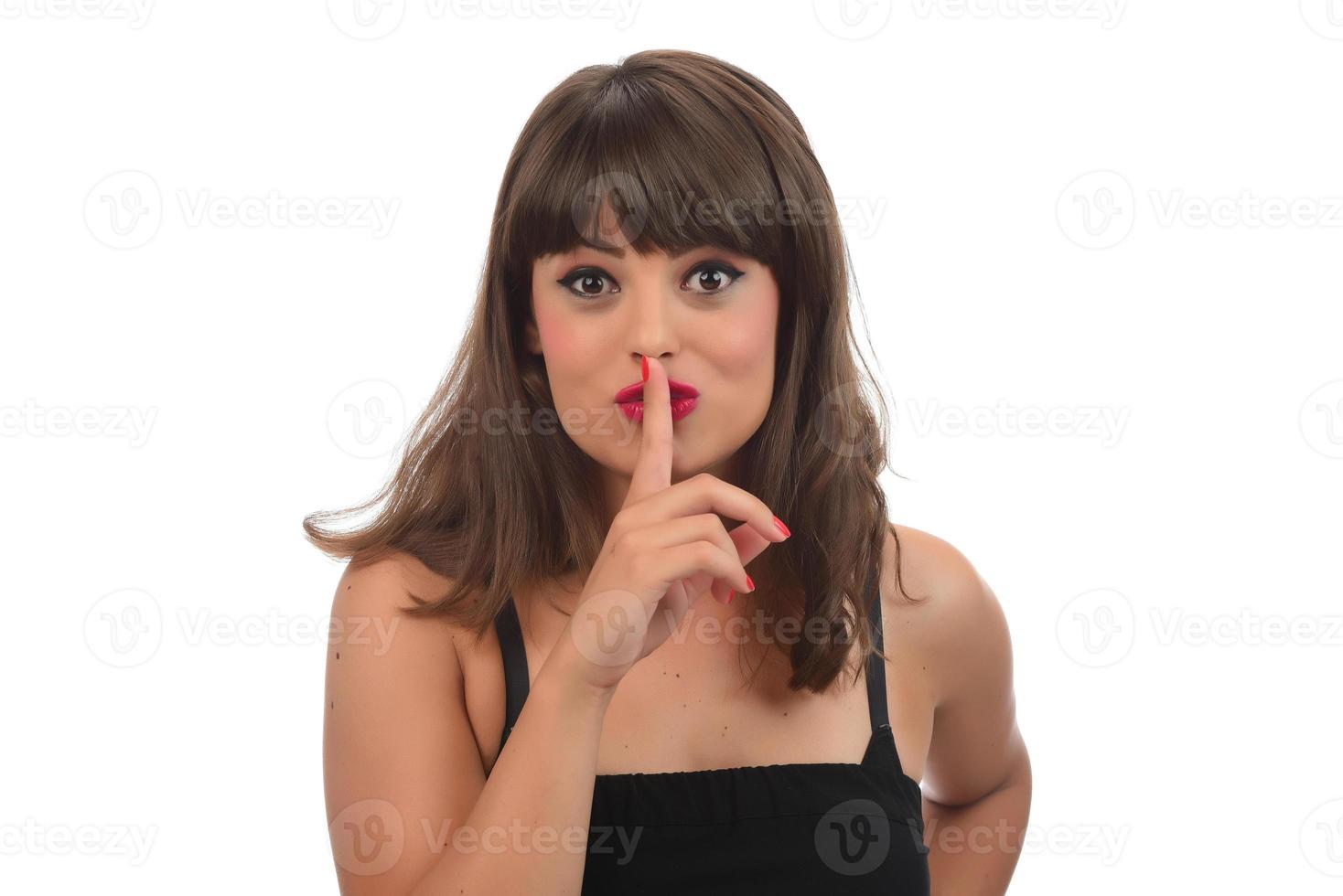 finger på läppar - tyst gest, kvinna håller fingret mot läpparna i en gest för tystnad. foto
