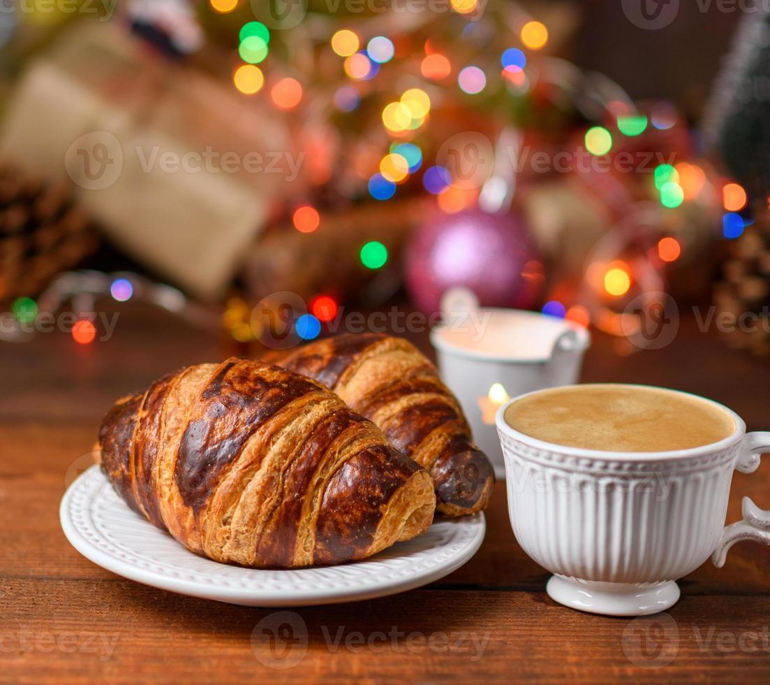 bakad croissanter och en vit keramisk kopp med kaffe foto