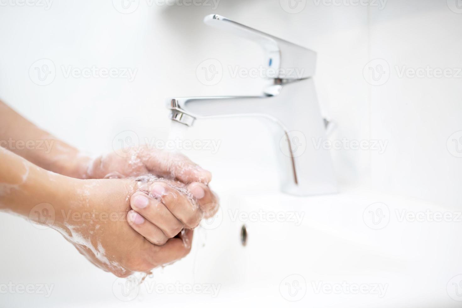 rengöring händer. tvättning händer med tvål under de kran med vatten betala smuts foto