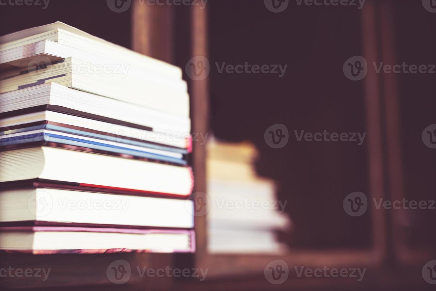 böcker är placerad på bokhylla i en bibliotek. utbildning begrepp. med filtrera toner retro årgång värma effekt. foto