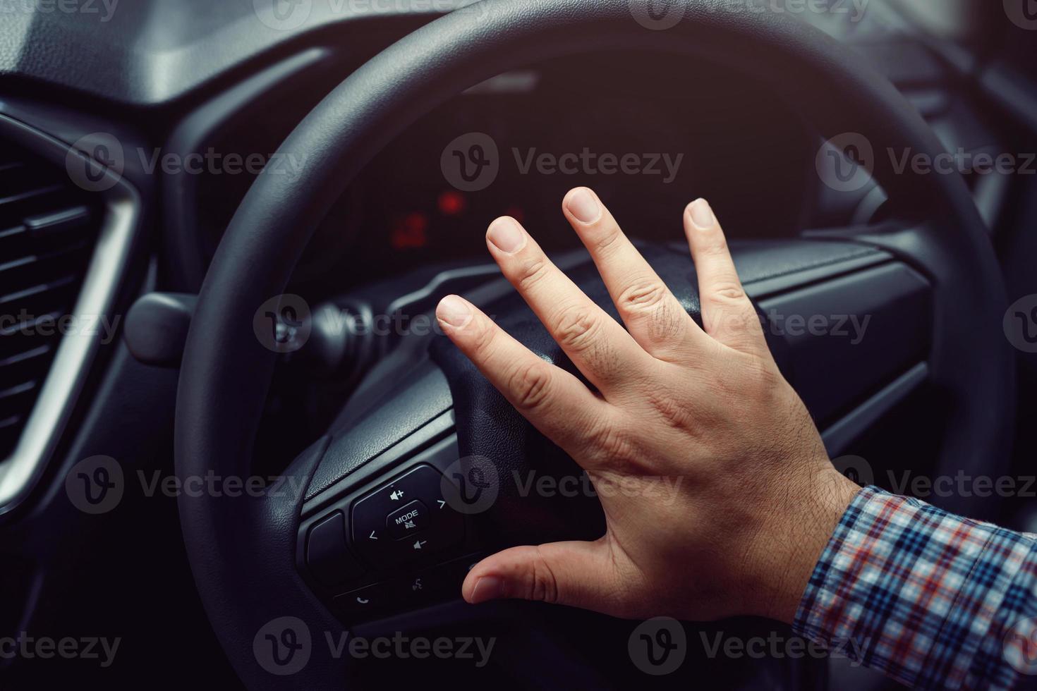 man tryckande horn medan körning Sammanträde av en styrning hjul Tryck bil, honking ljud till varna Övrig människor foto