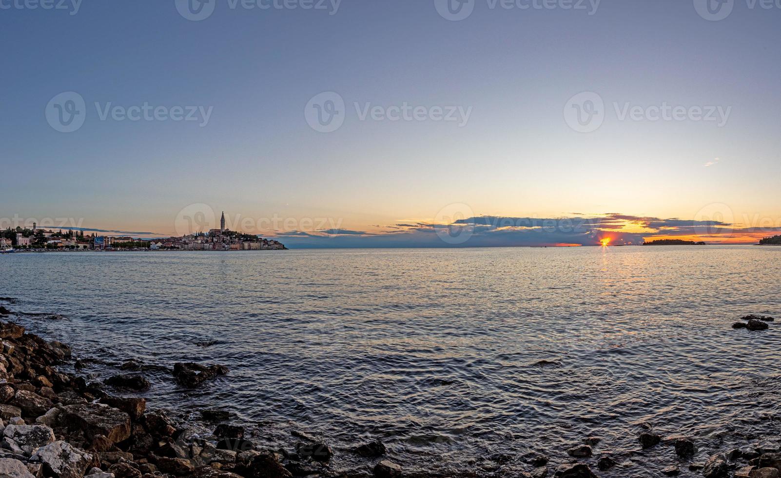 se till de historisk Centrum av rovinj under solnedgång med vatten reflektioner och trevlig moln formationer foto