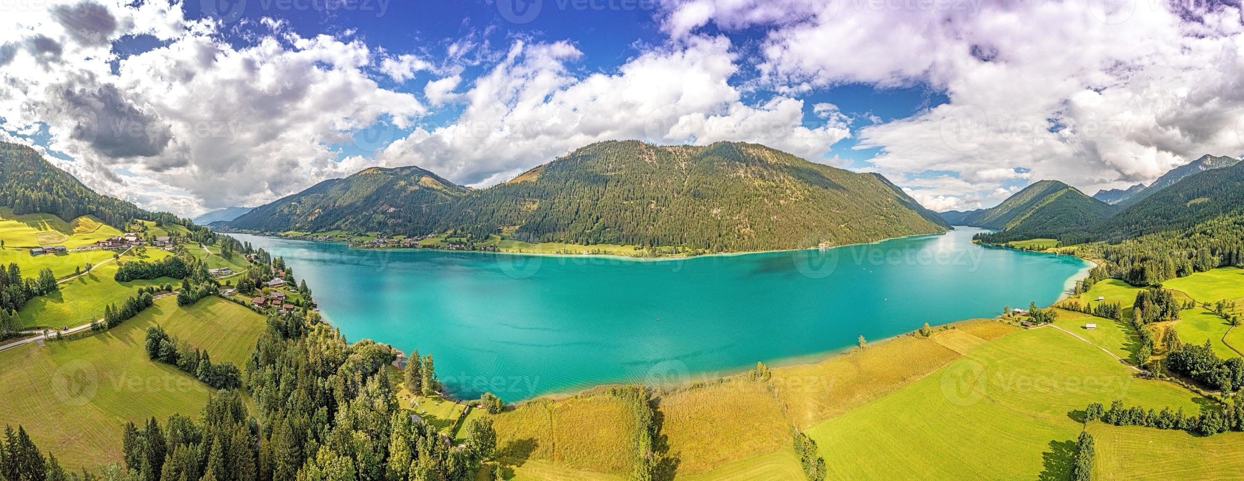 Drönare panorama över turkos sjö weissensee i österrikiska provins av Kärnten under dagtid foto