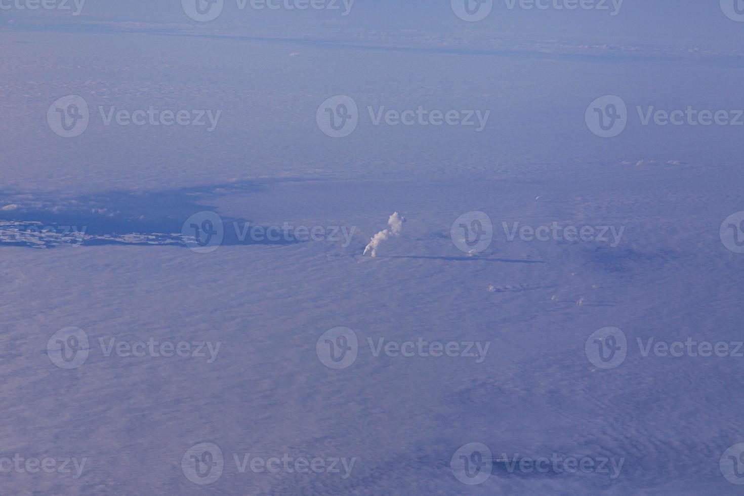 antenn bild av fuming industriell skorsten och molnig himmel foto