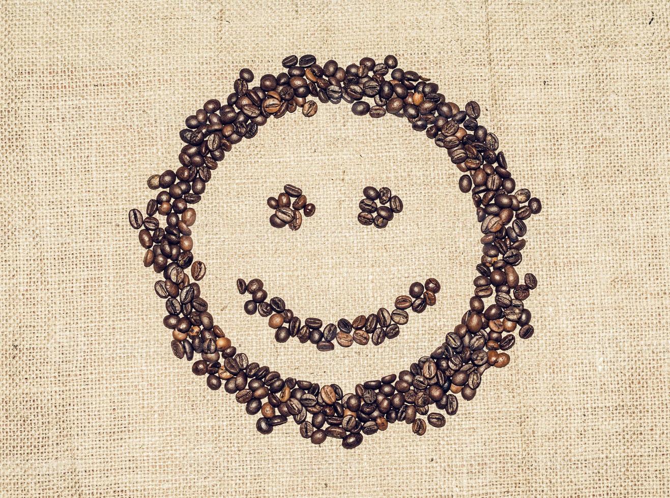 leende ansikte bildas förbi kaffe korn på grov trasa foto