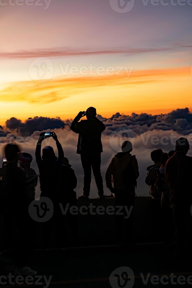 silhuett person grupp tittar på flytande hav av moln, hav av dimma, himmel ovan moln, tar clouds foton med mobil telefoner i de morgonsol stiga, resa lång helg, inhanon berg.