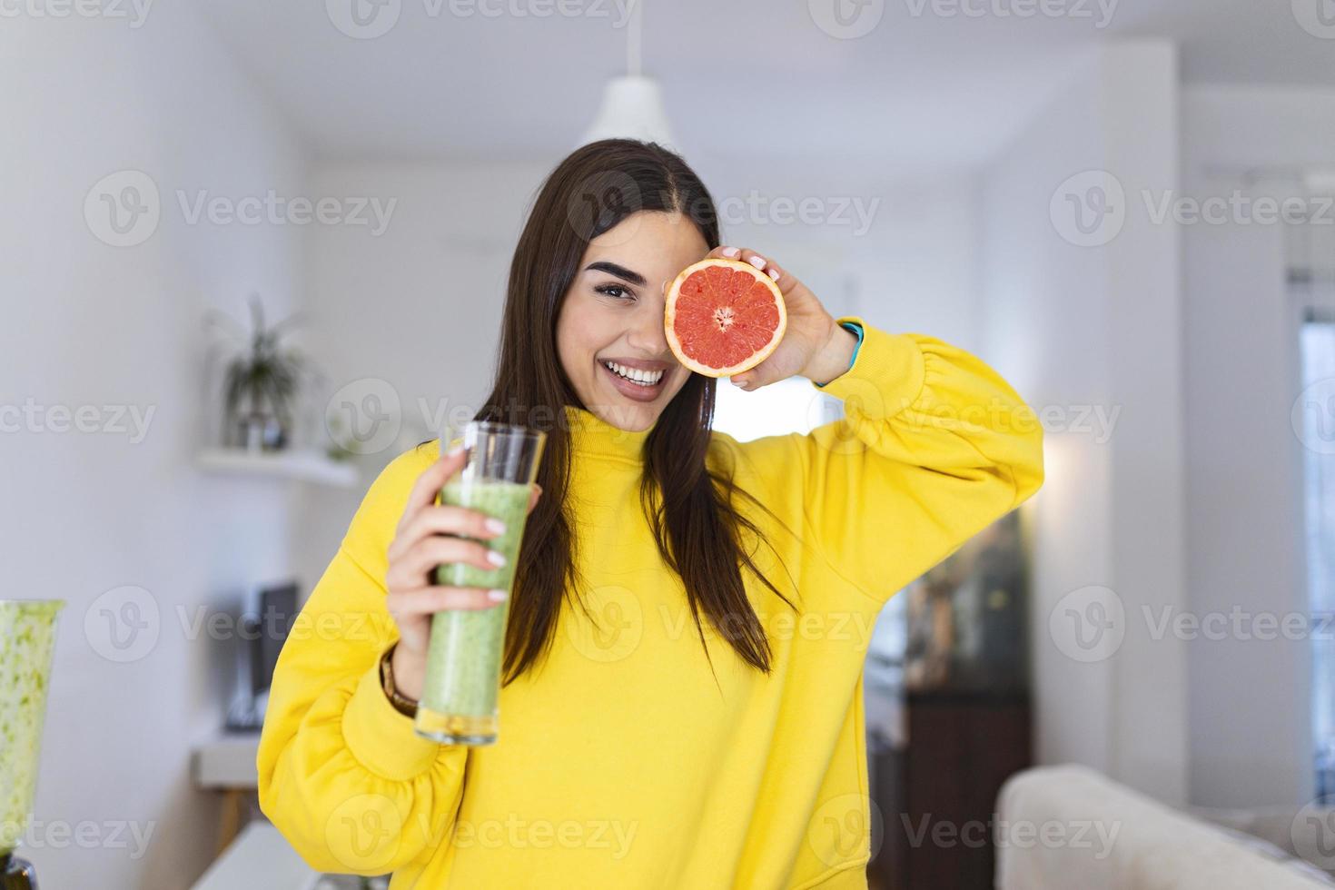 skön kvinna innehav glas av smoothie och grapefrukt. friska livsstil. rå mat diet, vegetarian näring, organisk detox måltid foto