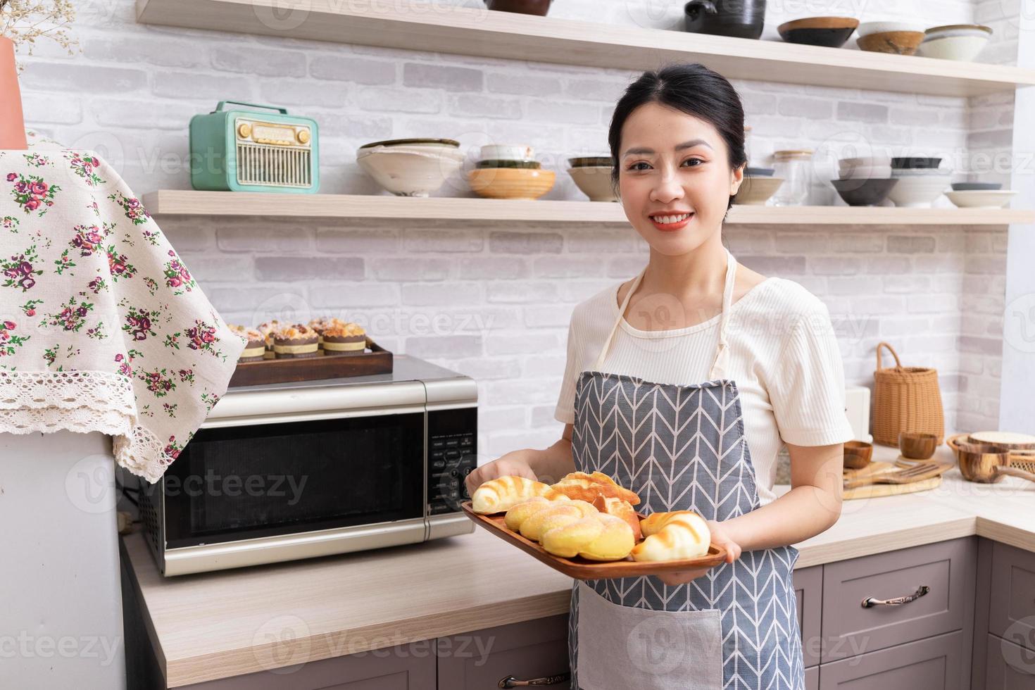 ung asiatisk kvinna framställning till laga mat i de kök foto