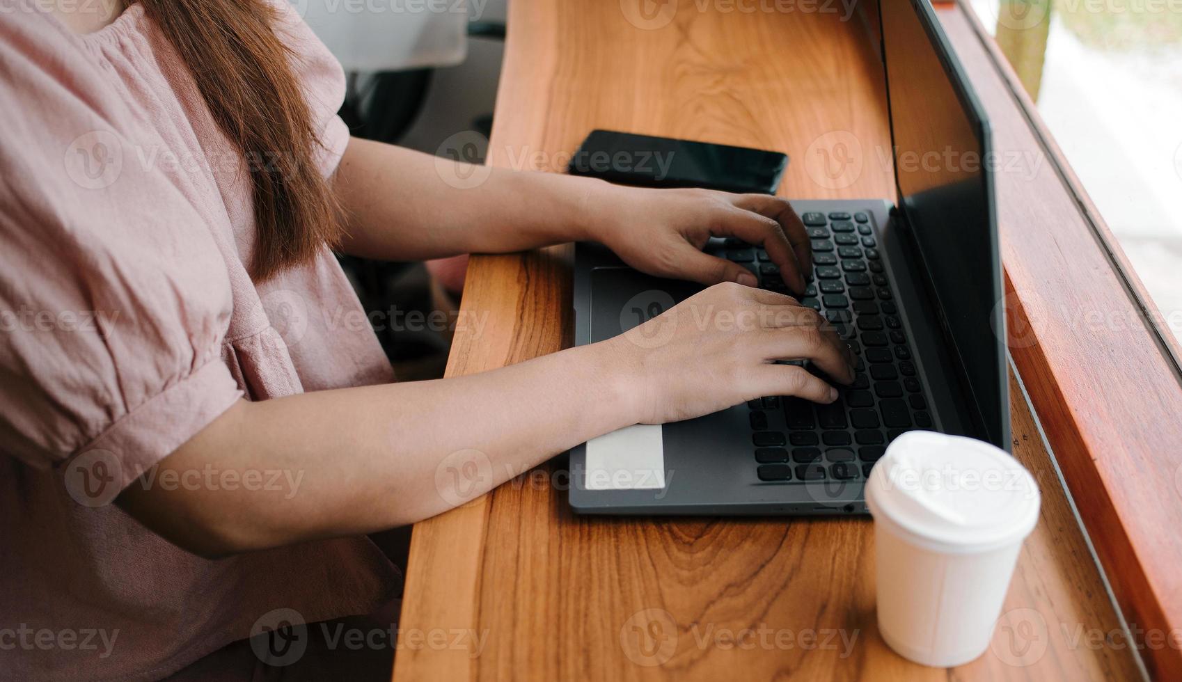 närbild av kvinnas händer skriver på en laptop.affärskvinna arbetssätt på en bärbar dator, gammal eller medelålders lady använder sig av dator begrepp skrivning mejl, kommunicerar uppkopplad, foto