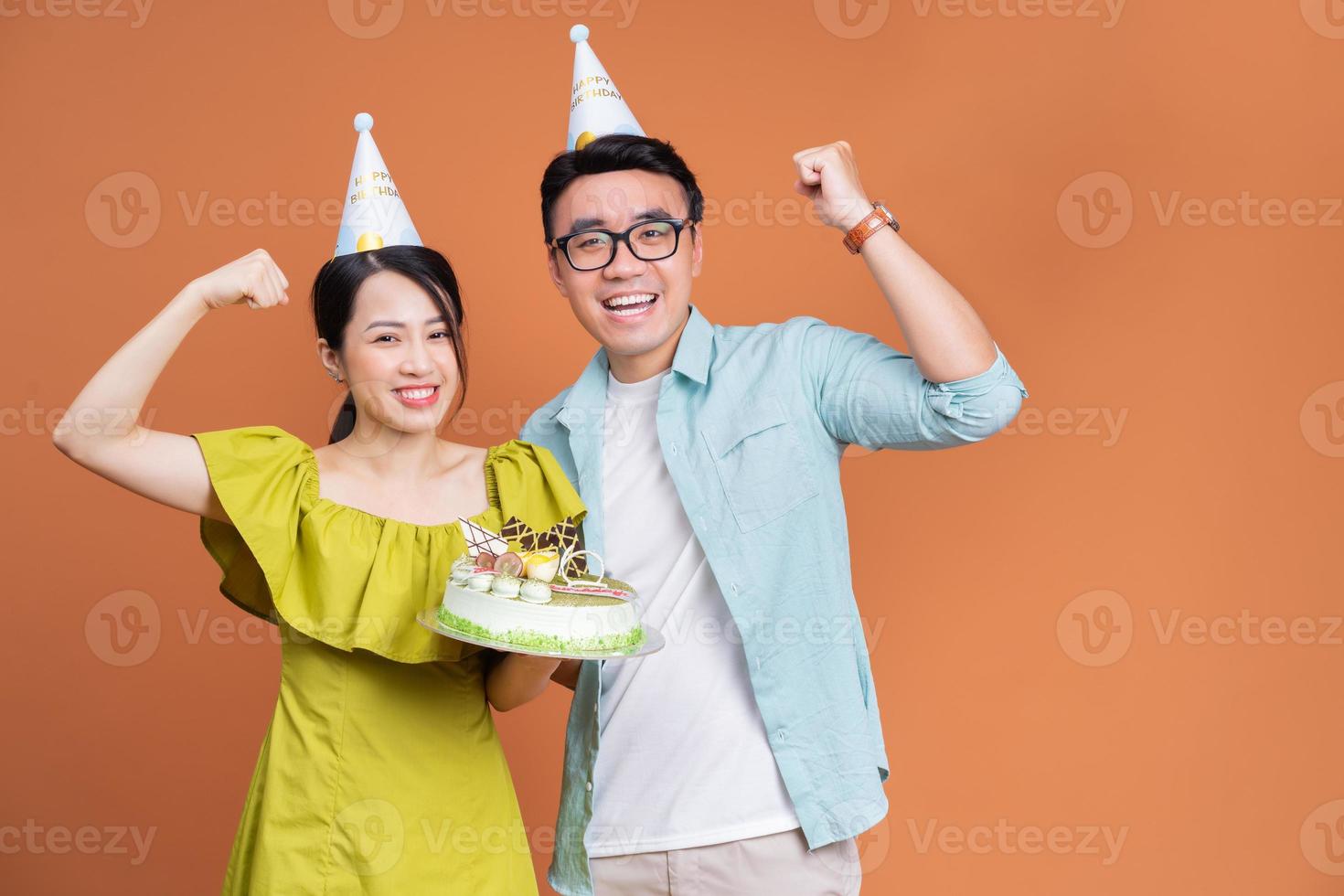 ung asiatisk par innehav födelsedag kaka på bakgrund foto