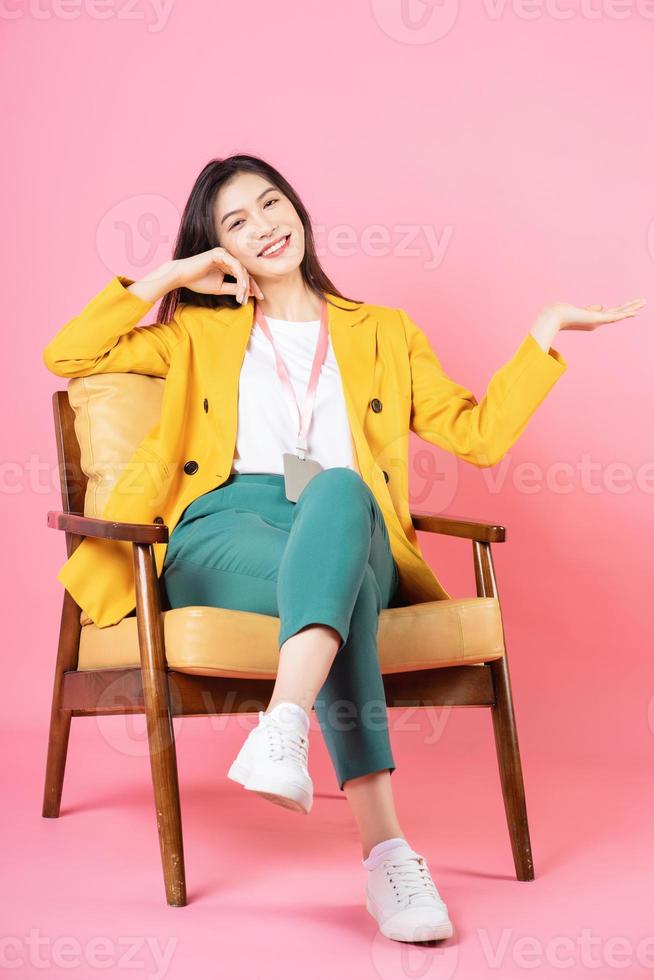 bild av ung asiatisk affärskvinna som sitter på stol foto