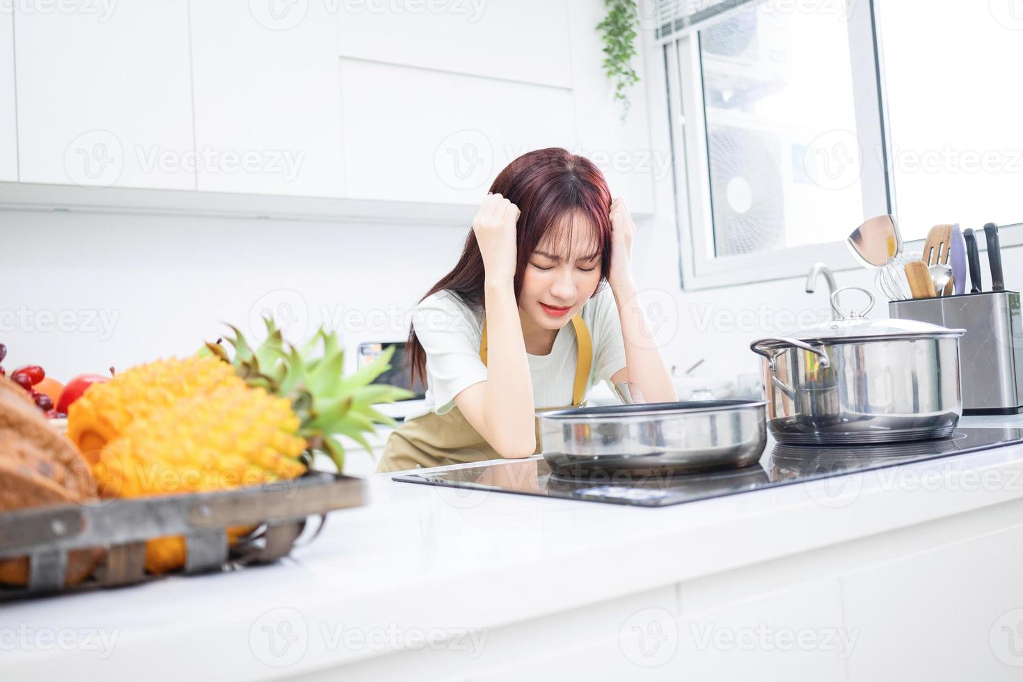 bild av ung asiatisk kvinna i de kök foto