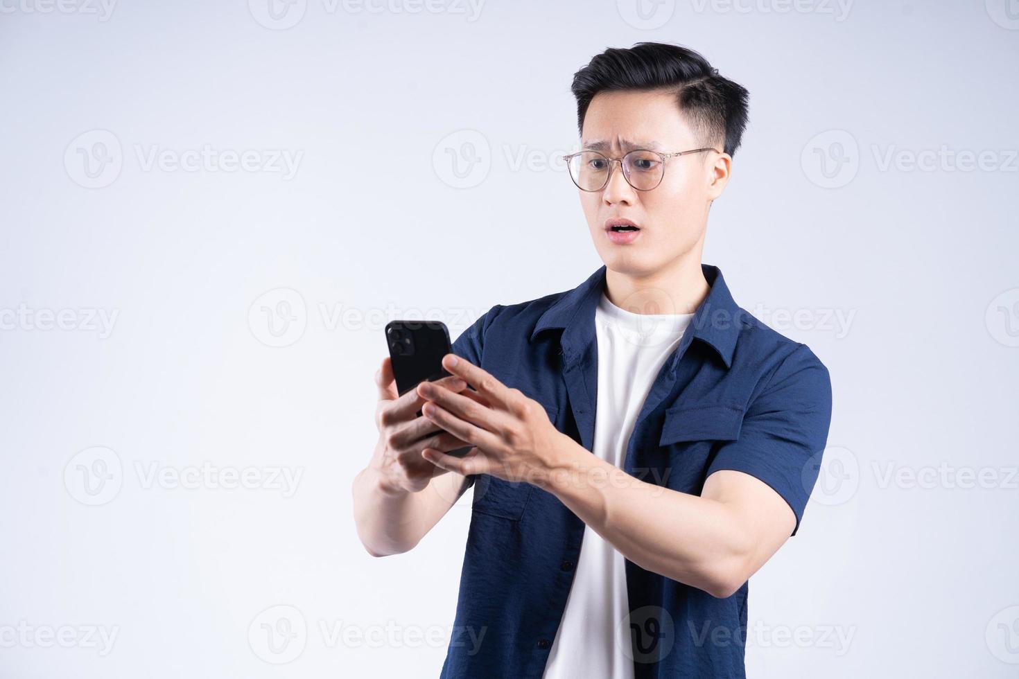 ung asiatisk man använder sig av smartphone på bakgrund foto
