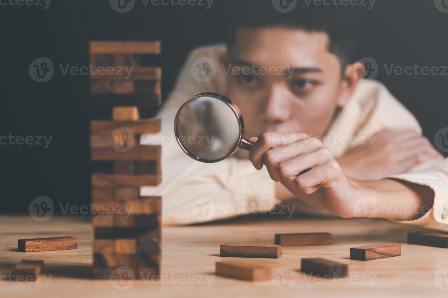 finansiell risk förvaltning och strategisk planera genom data analys för kontinuerlig förbättring visionär beslut för ledarskap framgång, a man innehav förstorande glas och trä- blockera på tabell foto