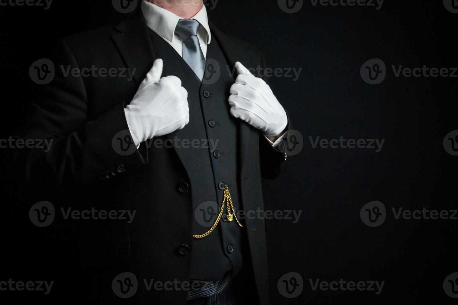 porträtt av butler i mörk kostym och vit handskar stående stolt. begrepp av service industri och professionell artighet. foto