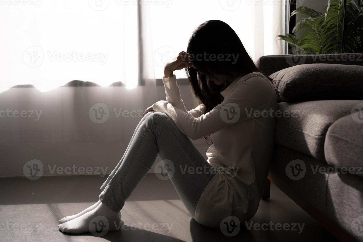ung kvinna känsla deprimerad och betonade Sammanträde i mörk sovrum. mental hälsa begrepp. foto