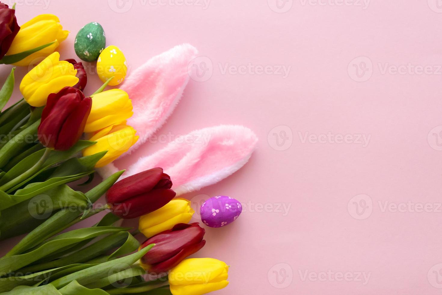 skön tulpaner, dekorerad påsk ägg och kanin öron på Färg rosa bakgrund, topp se foto