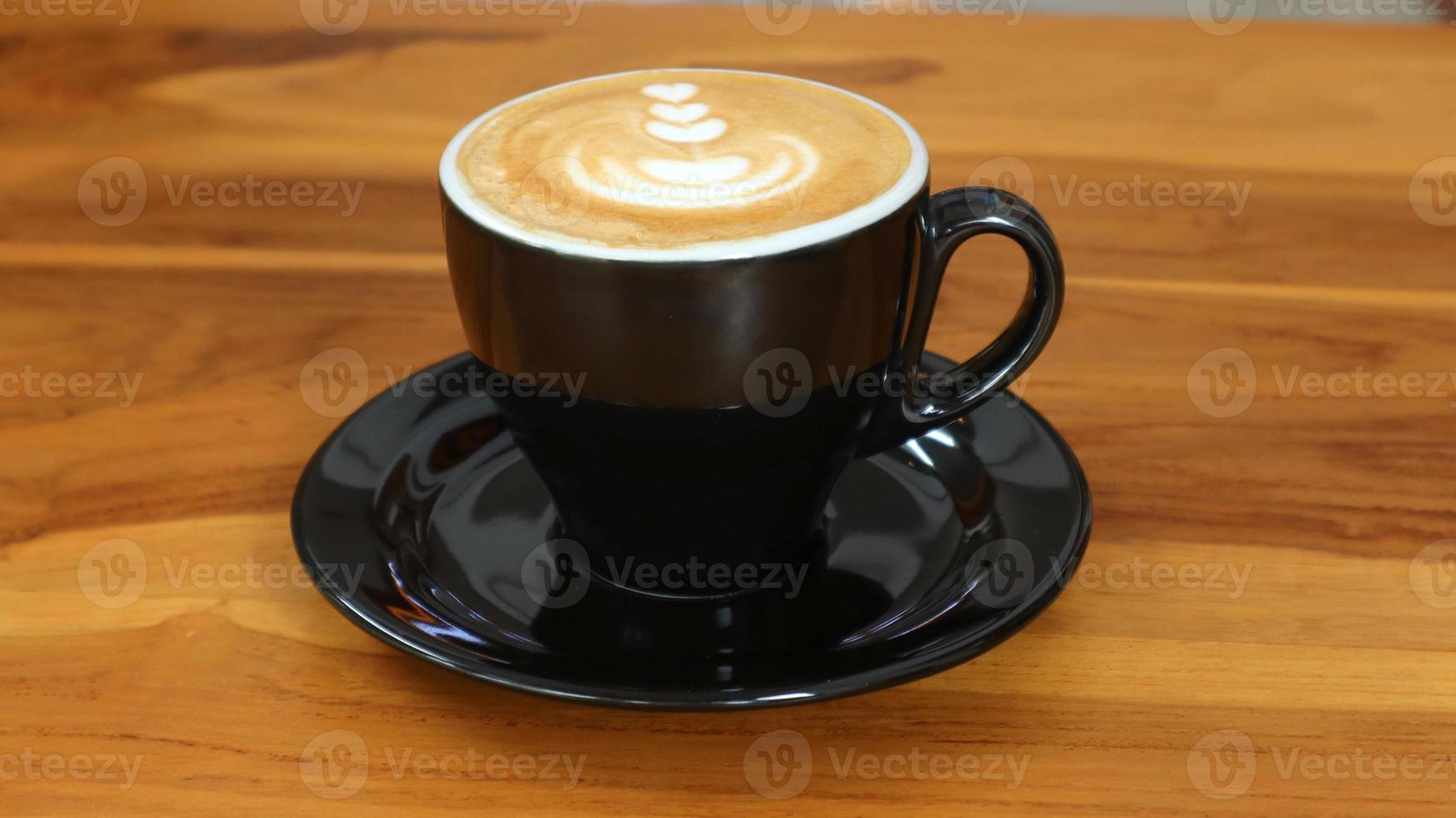 en glas av cappuccino kaffe med skum träsnideri på de tabell foto
