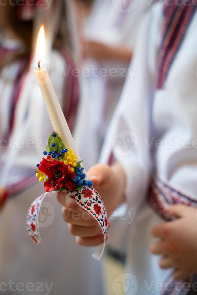 en barn innehar en ljus i hans hand i de kyrka under de service. foto