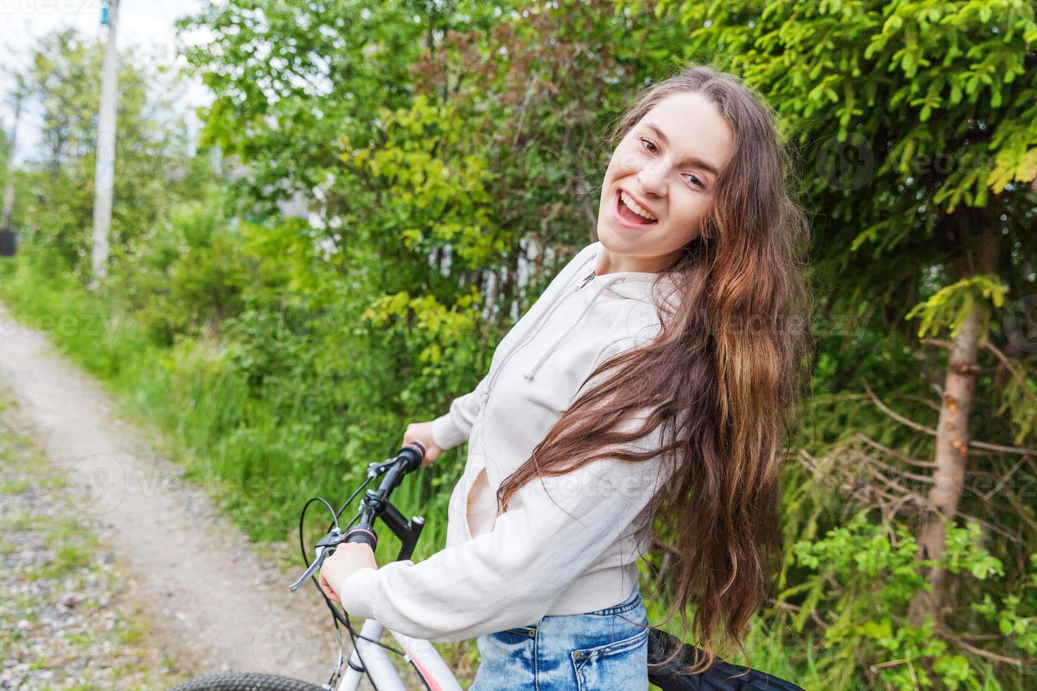 ung kvinna ridning cykel i sommar stad parkera utomhus. aktiva människor. hipster flicka koppla av och ryttare cykel foto