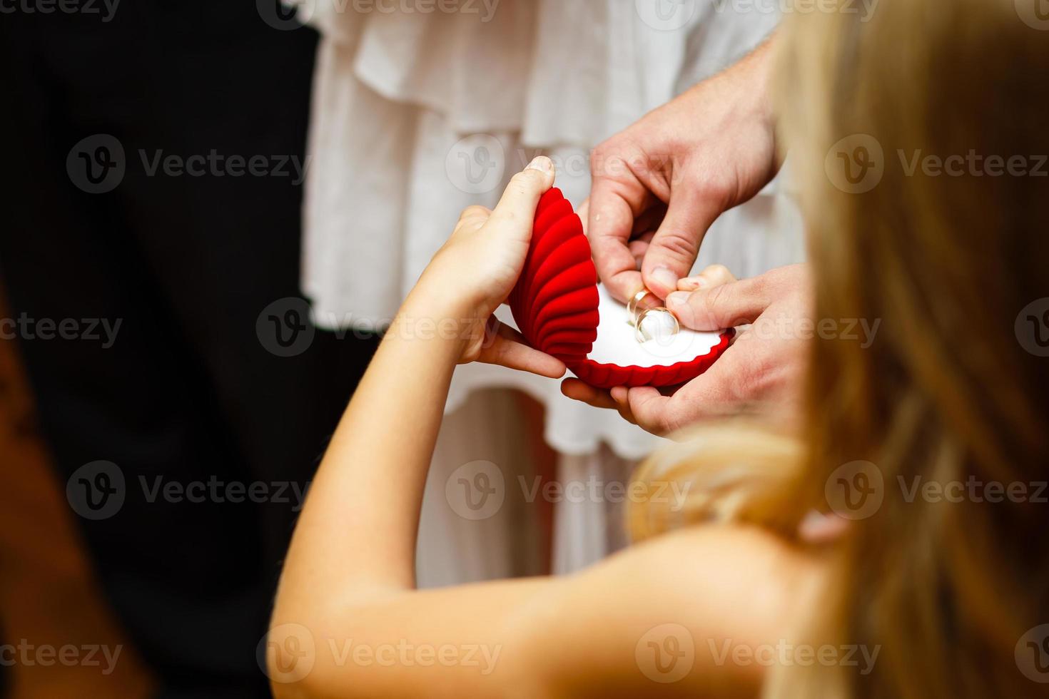liten flicka bärande bröllop ringa i en låda på de ceremoni foto