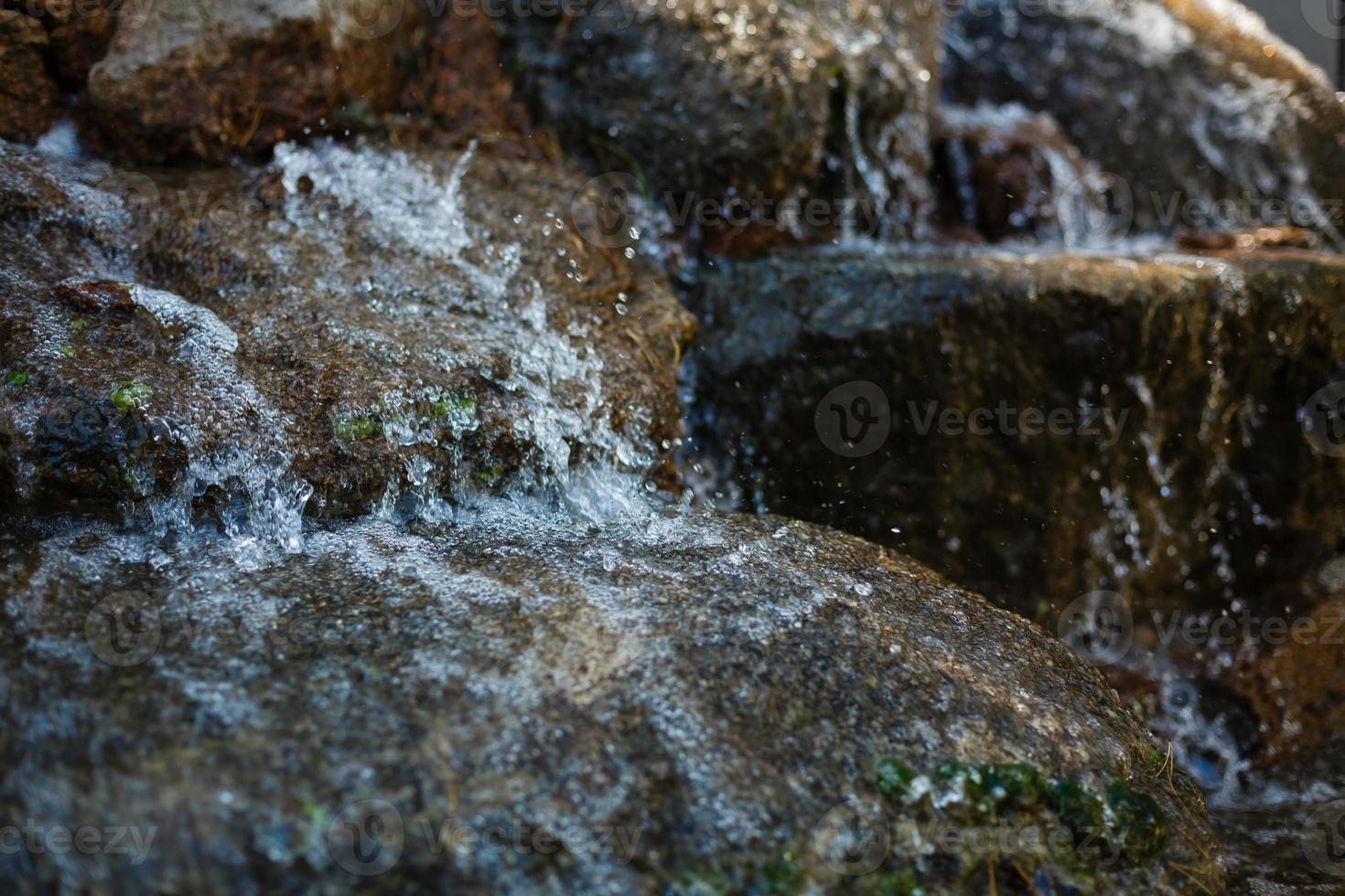 stänga upp av vatten stänk på stenar från en vattenfall foto