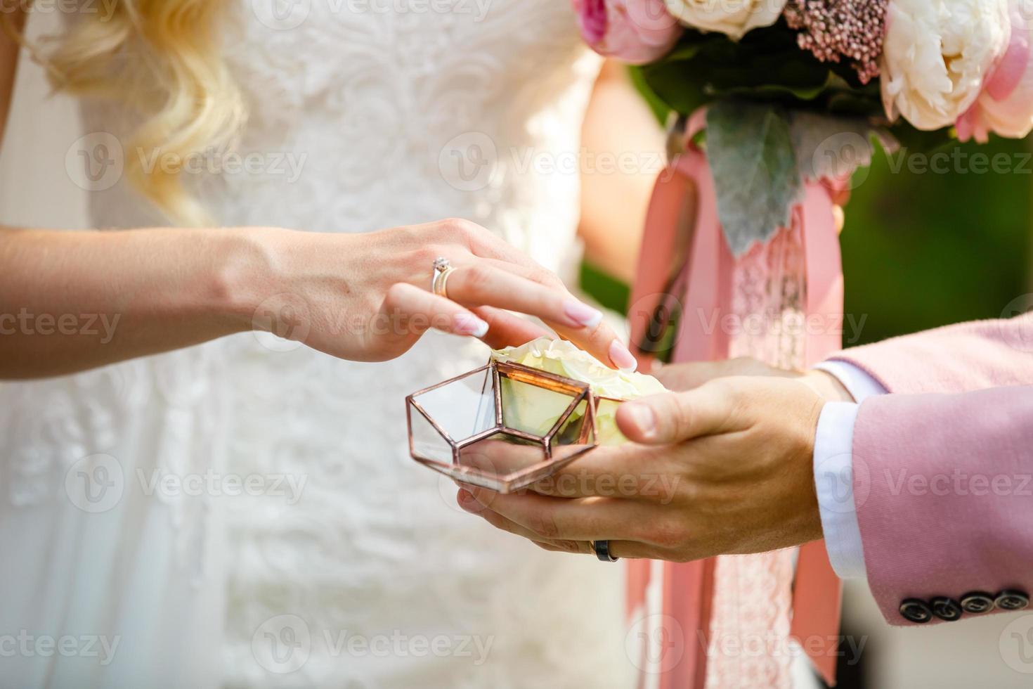 de brud och brudgum utbyta ringar under en bröllop ceremoni, en bröllop i de sommar trädgård foto