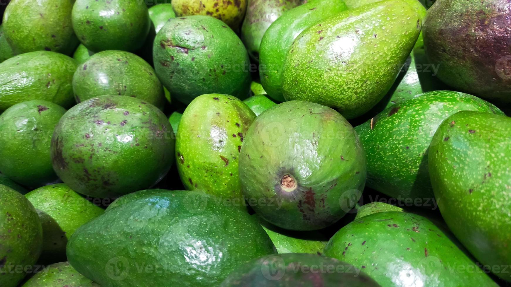 lugg av grön avokado på de marknadsföra för försäljning. foto