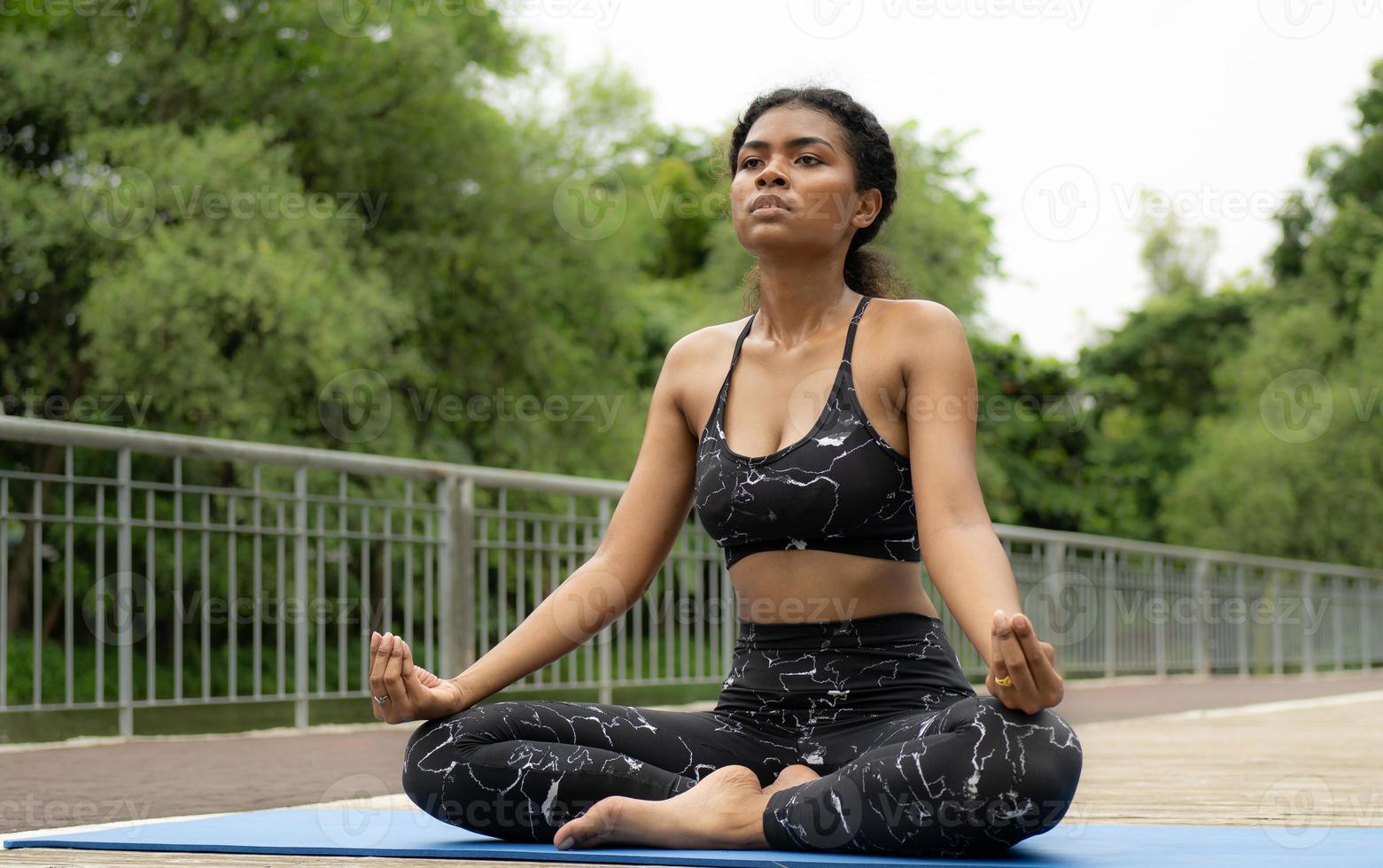 skön kvinna praktiserande yoga utomhus- i de lugn natur parkera. kvinna person fritid aktivitet är meditation, avslappning mindfulness övning för friska livsstil och fredlig andlighet. foto